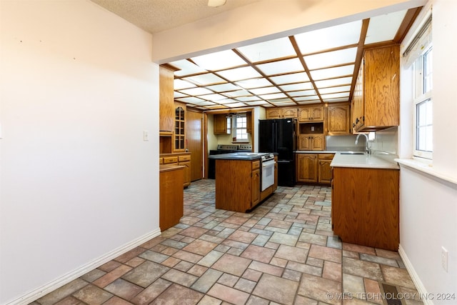 815 S Oak Grove Rd, Cushing, OK 74023 - kitchen featuring freestanding refrigerator, brown cabinets, a kitchen island, light stone finish flooring, and white range oven