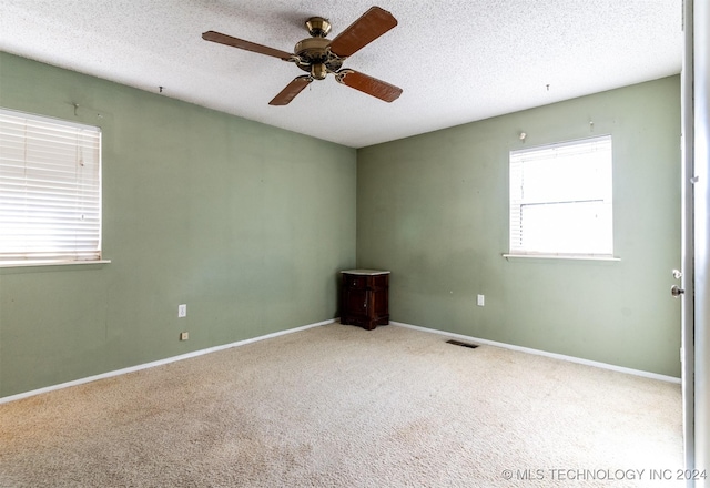 815 S Oak Grove Rd, Cushing, OK 74023 - unfurnished room with plenty of natural light, a ceiling fan, carpet floors, and a textured ceiling