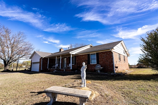 ranch-style house featuring a garage, a front yard, and a porch