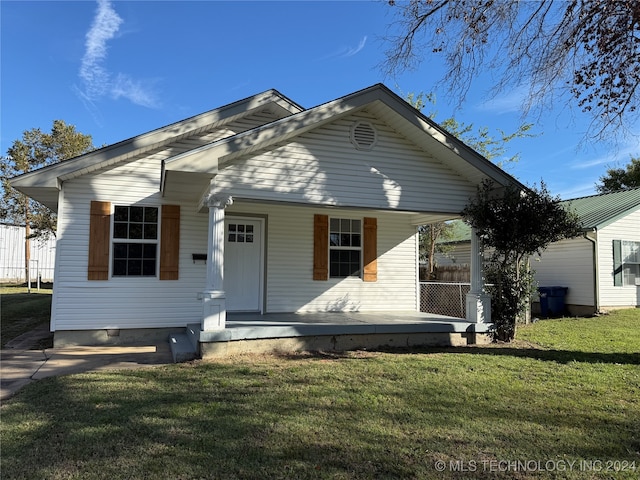 bungalow-style house with a front yard and covered porch