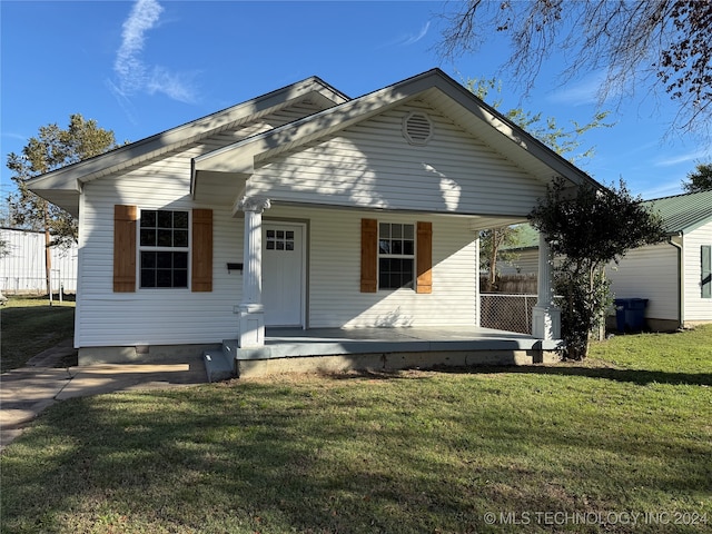 bungalow-style home with a front lawn and covered porch