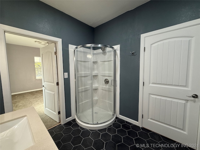 bathroom featuring tile patterned flooring, vanity, and a shower with shower door