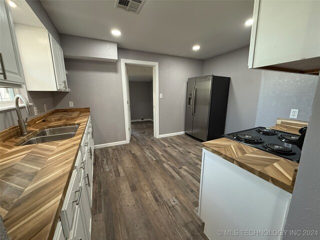 kitchen featuring sink, stainless steel fridge with ice dispenser, butcher block countertops, dark hardwood / wood-style floors, and white cabinetry