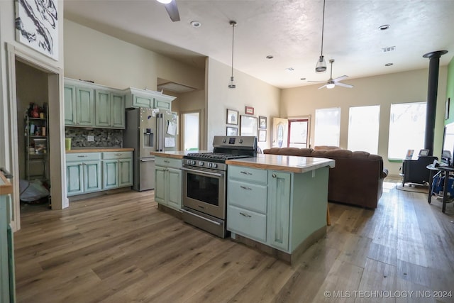 kitchen featuring stainless steel appliances, green cabinets, dark wood-type flooring, and a kitchen island