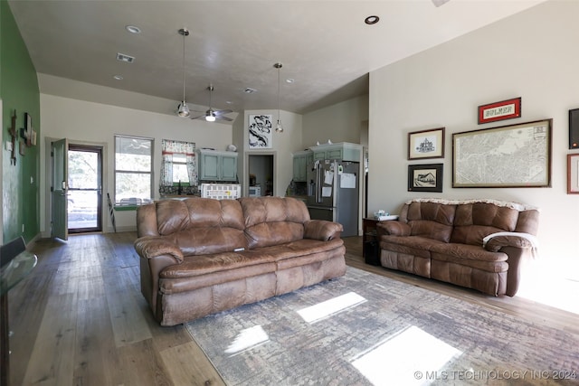 living room featuring a high ceiling, wood-type flooring, and ceiling fan