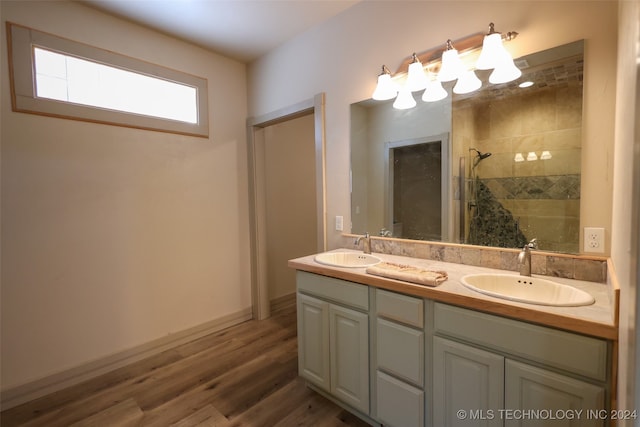 bathroom with tiled shower, wood-type flooring, and vanity