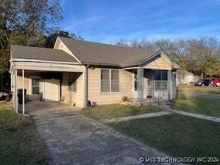 view of front of home with a carport and a front lawn