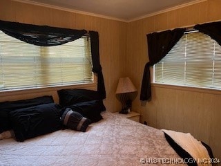 bedroom with ornamental molding and wood walls