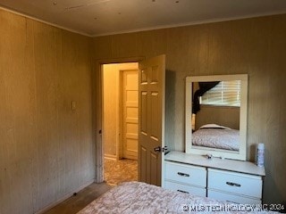 unfurnished bedroom with wooden walls and light wood-type flooring