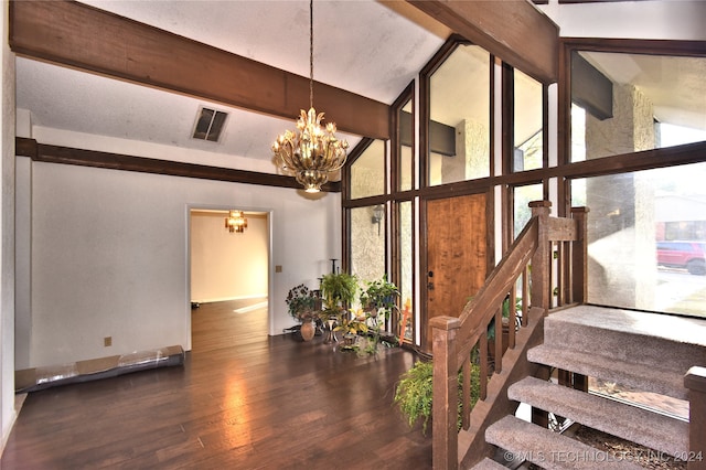 staircase featuring beamed ceiling, hardwood / wood-style floors, an inviting chandelier, and expansive windows