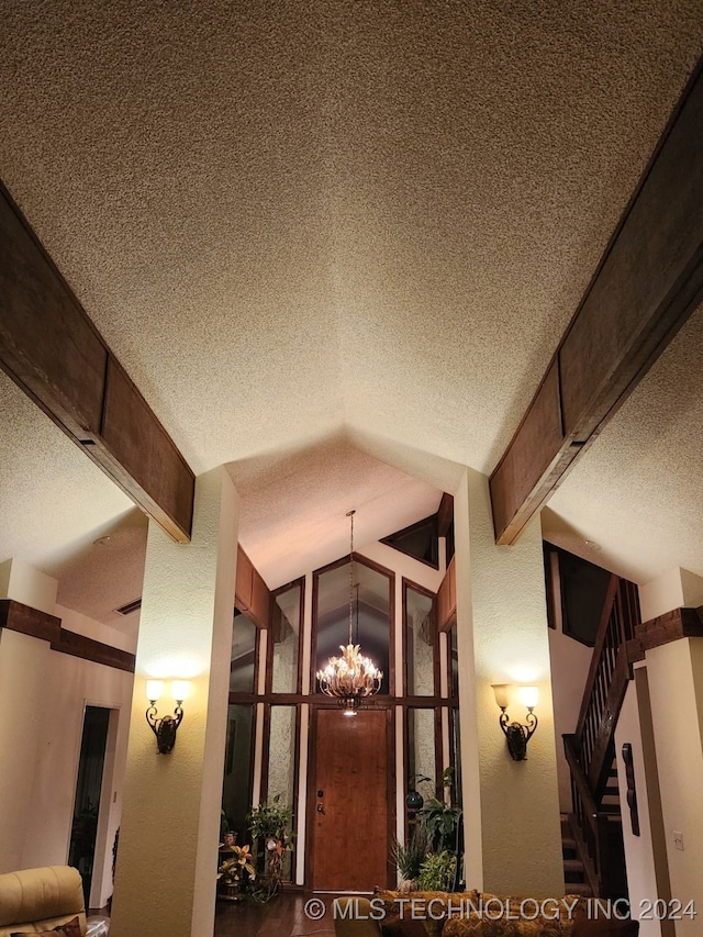 room details featuring beam ceiling, a textured ceiling, and a notable chandelier