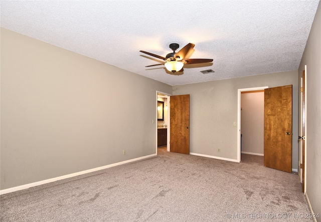 unfurnished bedroom featuring ceiling fan, a closet, carpet floors, and a textured ceiling