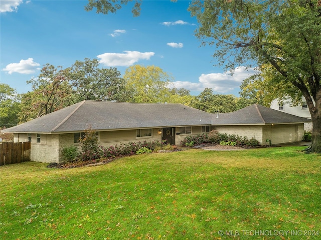 rear view of house featuring a lawn and a garage