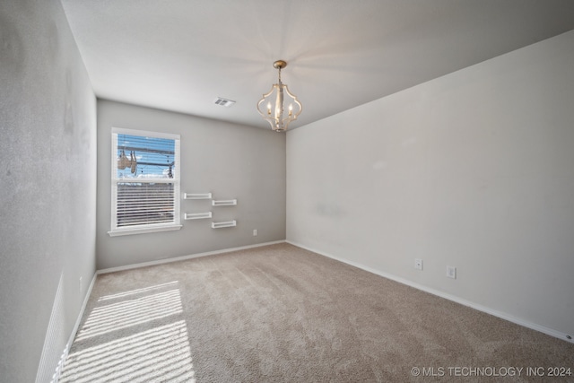 unfurnished room with a notable chandelier and light carpet