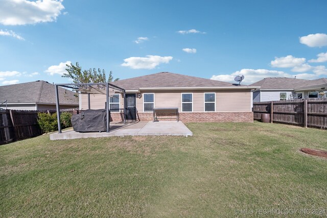 rear view of property featuring a pergola, a patio, and a yard