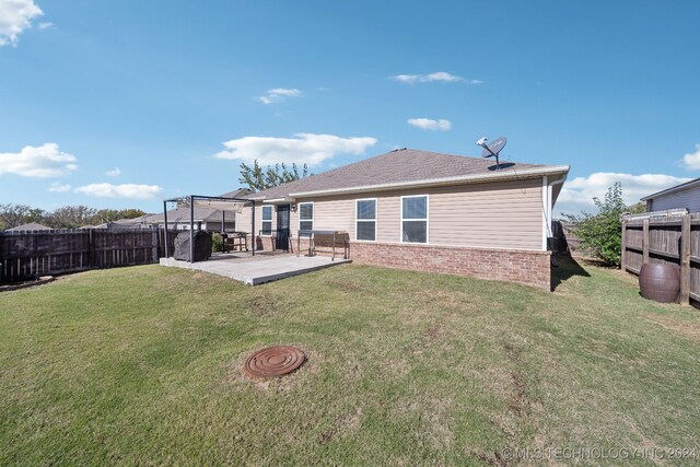 rear view of house featuring a lawn and a patio area