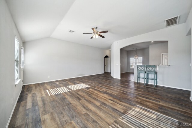 unfurnished living room featuring lofted ceiling, ceiling fan, and dark hardwood / wood-style flooring