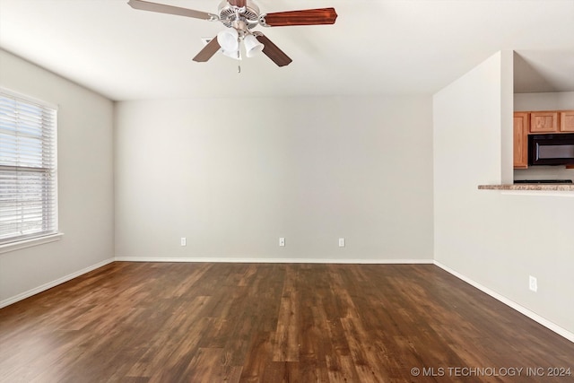 spare room with ceiling fan and dark hardwood / wood-style flooring