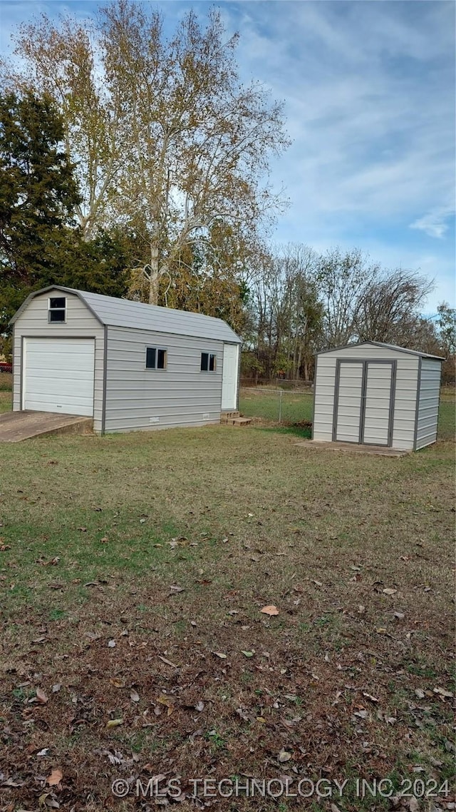 view of yard featuring a garage and an outbuilding