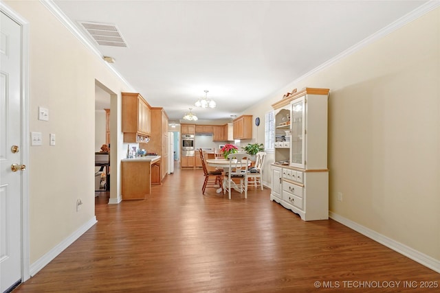 dining room with an inviting chandelier, ornamental molding, and hardwood / wood-style floors