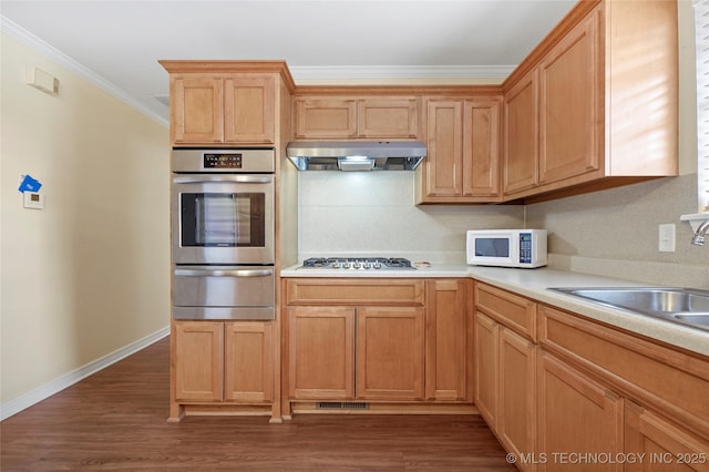 kitchen with stainless steel appliances, backsplash, dark hardwood / wood-style flooring, crown molding, and sink