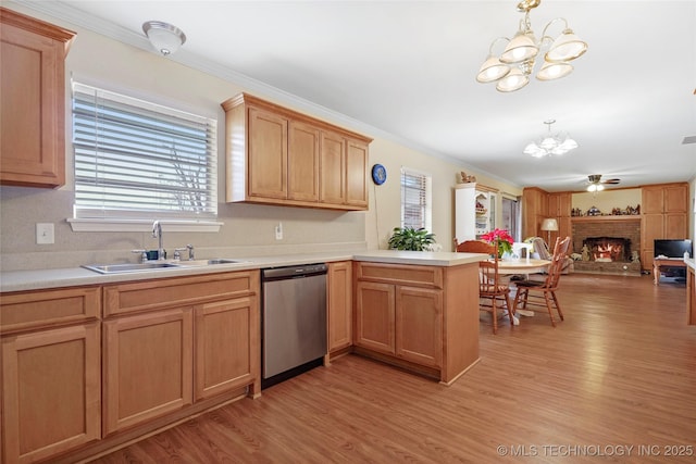 kitchen with ceiling fan with notable chandelier, dishwasher, a fireplace, sink, and kitchen peninsula