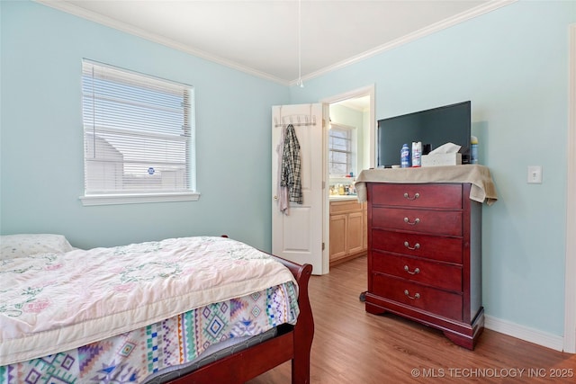 bedroom with light wood-type flooring, ensuite bathroom, and crown molding