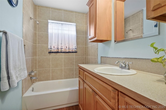 bathroom with tiled shower / bath and vanity