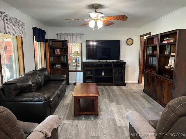 living room featuring ceiling fan, light wood-type flooring, and crown molding