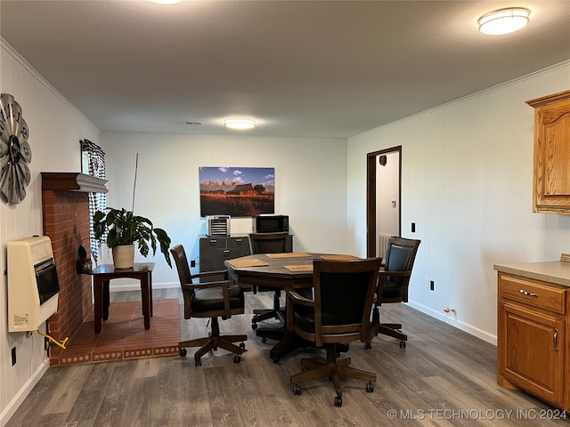 dining room featuring dark wood-type flooring, heating unit, and ornamental molding