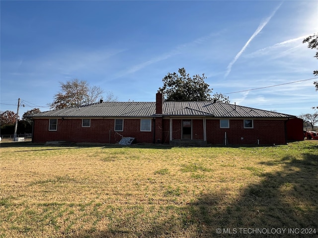 back of property featuring a lawn