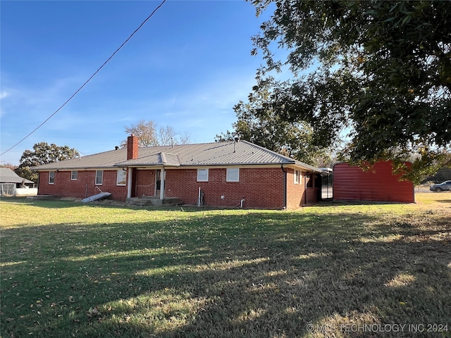 rear view of property with a lawn