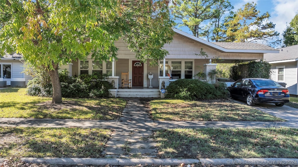 obstructed view of property featuring a porch and a front lawn