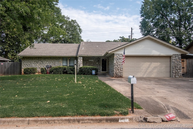 ranch-style house featuring a garage and a front yard