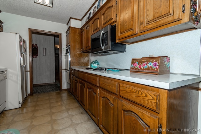 kitchen with appliances with stainless steel finishes and a textured ceiling