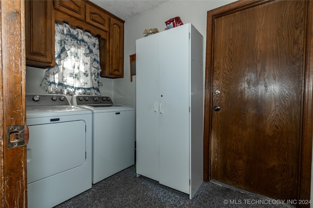 laundry room featuring washing machine and dryer, cabinets, and a textured ceiling