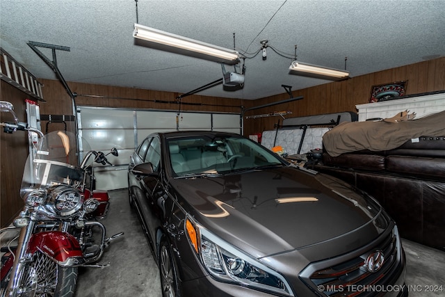 garage with wood walls and a garage door opener