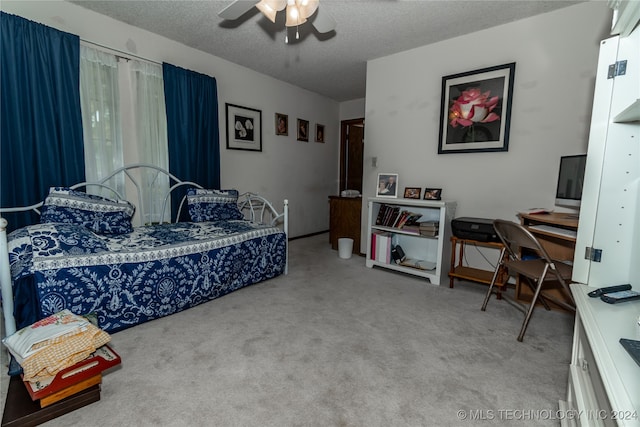 bedroom with a textured ceiling, carpet, and ceiling fan