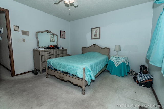 carpeted bedroom featuring a textured ceiling and ceiling fan