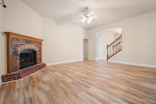 unfurnished living room with ceiling fan, light hardwood / wood-style floors, and a brick fireplace