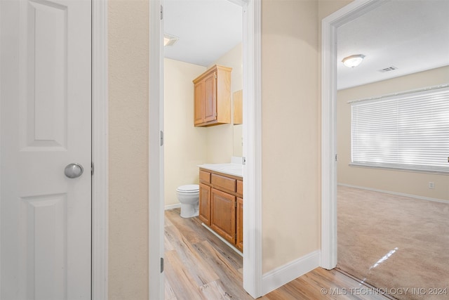 bathroom with wood-type flooring, vanity, and toilet