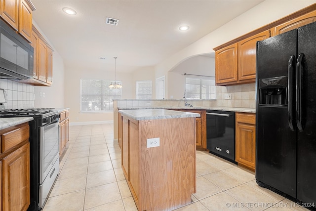 kitchen with black appliances, a kitchen island, backsplash, and a healthy amount of sunlight