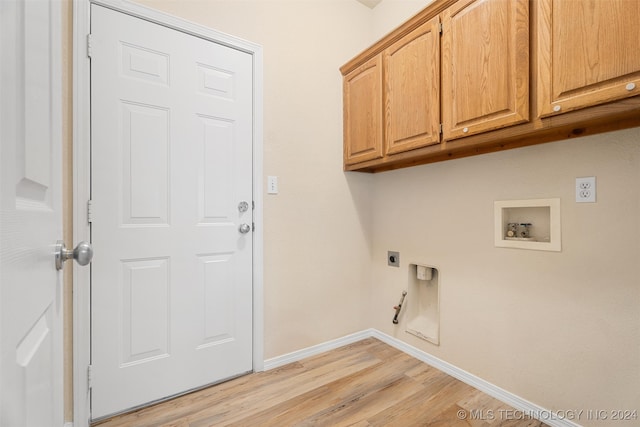 laundry room featuring cabinets, light hardwood / wood-style floors, hookup for an electric dryer, gas dryer hookup, and hookup for a washing machine