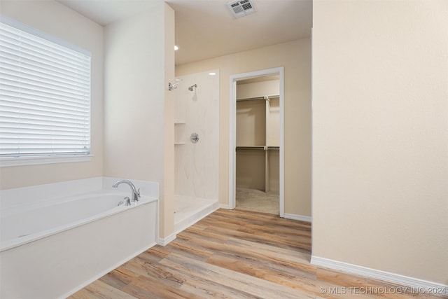 bathroom with hardwood / wood-style flooring and plus walk in shower