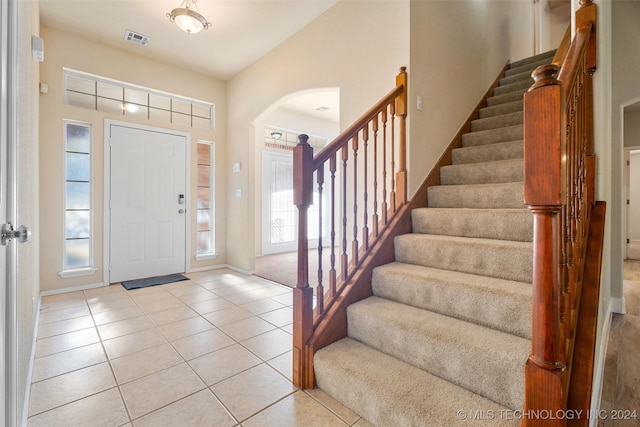 entrance foyer with lofted ceiling and light tile patterned flooring