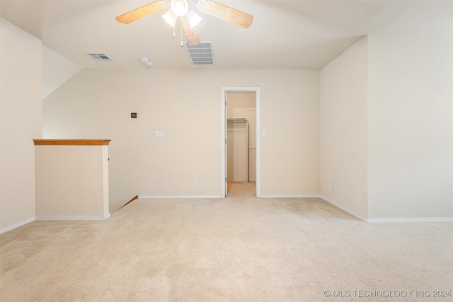 empty room featuring lofted ceiling, light colored carpet, and ceiling fan