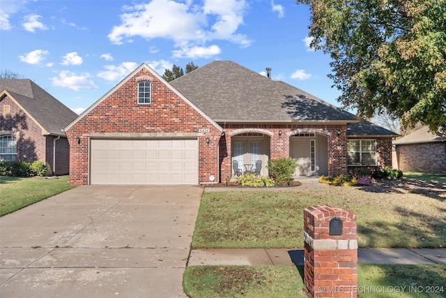 front facade featuring a garage and a front lawn