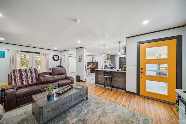 living room featuring bar, french doors, and light wood-type flooring