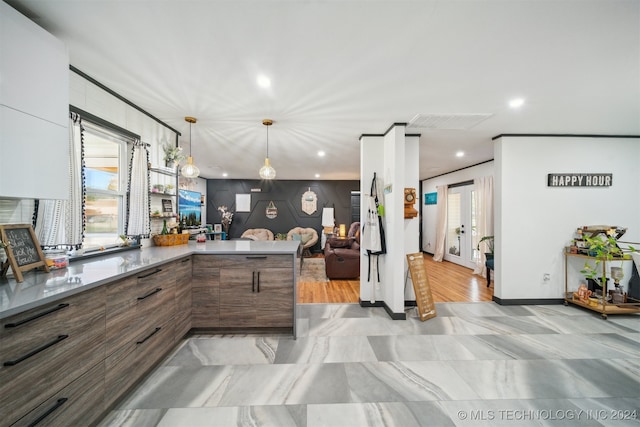 kitchen with dark brown cabinetry, hanging light fixtures, kitchen peninsula, and french doors