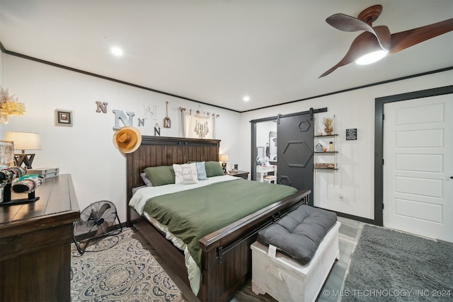 bedroom featuring ceiling fan, ornamental molding, and a barn door